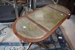 A reproduction Regency coffee table having oval top with green leather inset, approx. 106 x 45cm