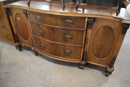 A Victorian walnut sideboard having serpentine top over three central bow fronted drawers with