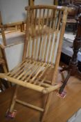 A vintage folding bamboo chair, sold with loose cushion