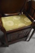 A late Victorian piano stool having storage to drop down front