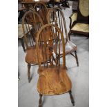 A set of four traditional solid seat kitchen chairs having Glenister Windsor style back with
