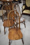 A set of four traditional solid seat kitchen chairs having Glenister Windsor style back with
