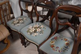 A harlequin set of three Victorian mahogany balloon back dining chairs having later tapestry seat on