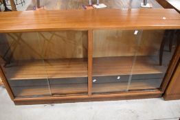 Two vintage sapele low double bookcases, having sliding glass doors, width approx. 136cm each