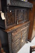 A traditional oak court cupboard, probably 19th century , having carved decoration throughout ,