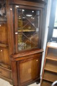 An Edwardian mahogany corner cabinet having astral glazed top over cupboard base, with inlaid