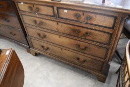 A Georgian oak and mahogany cross banded chest of two over three drawers having brass drop