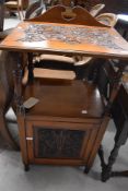 A Victorian mahogany pot cupboard in the Arts and Crafts style having pokerworked and carved top and