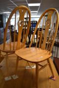 A pair of Ercol hoop back dining chairs with swan carving to centre rail