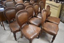 A set of twelve (ten plus two) Victorian oak dining chairs having spoon backs and overstuffed seats,