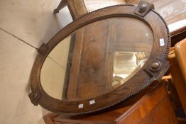 A late 19th or early 20th Century oak oval wall mirror, approx. 65 x 90cm