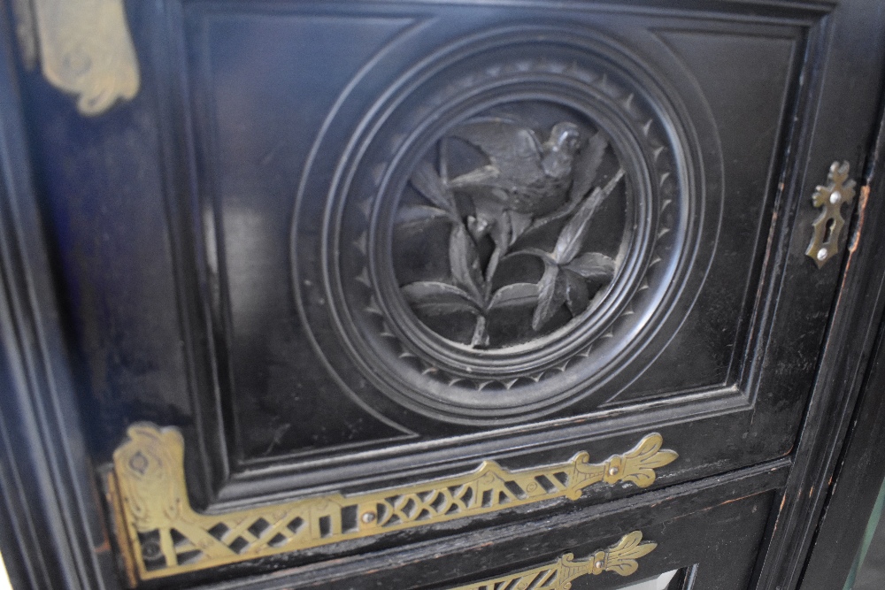 A late Victorian ebonised display cabinet in the Aesthetic style, having elaborate brass hinges, - Image 2 of 3
