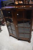 An early 20th Century oak display cabinet having solid wood shelved , and a hint of Deco design in