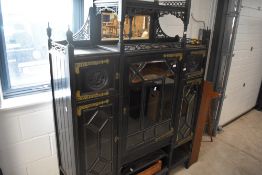 A late Victorian ebonised display cabinet in the Aesthetic style, having elaborate brass hinges,
