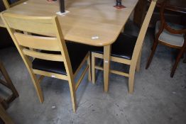 A modern beech laminate drop leaf kitchen table and four chairs