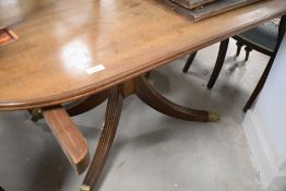 An early 20th Century Regency revival mahogany extending twin pedestal dining table of typical