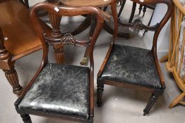 A pair of Victorian mahogany rail back dining chairs having drop in seats and turned legs