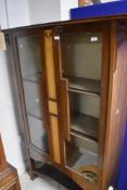 An Art Nouveau mahogany display cabinet having typical inlaid decoration in the Liberty's/Shapland