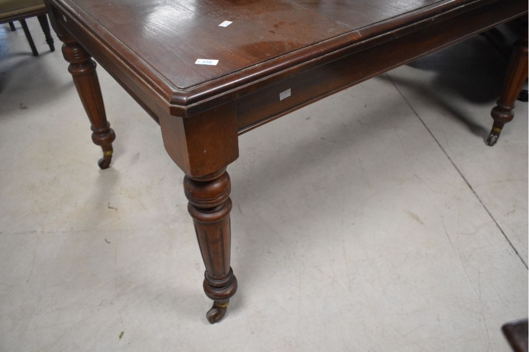 A late Victorian mahogany extending dining table, of rectangular form with moulded edge detail and - Image 1 of 3
