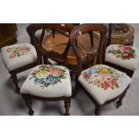 A set of four Victorian mahogany balloon back dining chairs having later tapestry foliate decoration