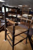 A 19th Century ladder back carver chair having rush seat