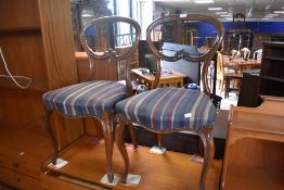 A pair of Victorian mahogany salon chairs having later stripe upholstery