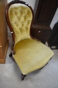 A Victorian mahogany framed spoon back nursing chair, having mustard dralon button back upholstery