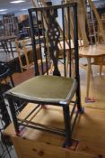 A late 19th or early 20th Century low chair having spindle and wheel back
