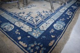 A vintage carpet square having cream and blue ground, approx. 274 x 200cm