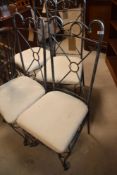 A set of four modern metal chairs having upholstered seats