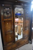 An early 20th Century oak wardrobe having central mirror door, Jacobean style applique , with drawer