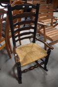 A 19th Century ladder back rocking chair having rush seat