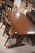 A dark stained Ercol drawer leaf dining table and set of four similar Ercol chairs