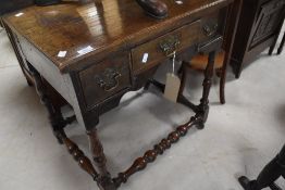 A 19th Century oak side table having three drawers with Georgian style brass handles and turned legs