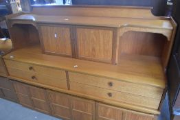 A vintage teak sideboard having raised back with cocktail cabinet section over four drawers and