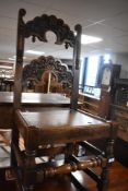 A 19th Century oak solid seat dining or hall chairs having figural and scroll decoration to back