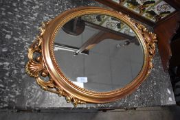 A reproduction gilt frame wall mirror having urn and swag decoration, approx. height 76cm