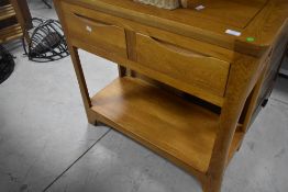 A modern golden oak hall table having two drawers and undershelf