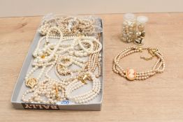 An assortment of faux pearl necklaces, some having decorative clasps