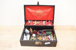 A black faux leather jewellery box, containing an assortment of costume jewellery including