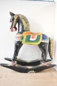 A vintage Balinese-style hand carved decorative wooden rocking horse, having colourful hand