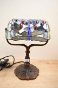 A small contemporary Tiffany-style dragonfly table lamp, featuring a leaded blue shade with a