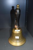 A large early 20th-century brass hand bell, having a turned wood handle, unmarked, 29cm in height,