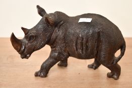 A vintage African hand carved ebonised wood rhino figure, featuring textured skin and strongly