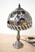 A small late 20th-century Tiffany-style table lamp, featuring a domed shade with star decoration and