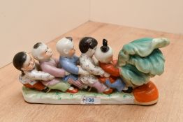A vintage Chinese porcelain figurine, depicting five traditionally dressed children harvest a