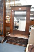 An early 20th-century Arts and Crafts oak hall mirror with candle box, featuring a hand carved
