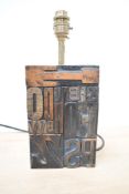 A contemporary Industrial-style table lamp, featuring vintage wooden typographical printing