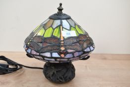 A small contemporary Tiffany-style dragonfly table lamp, featuring a colourful leaded shade with
