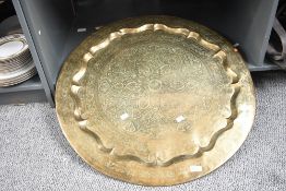 A large 20th-century Middle Eastern-style brass charger, having floral and foliate etched detailing,